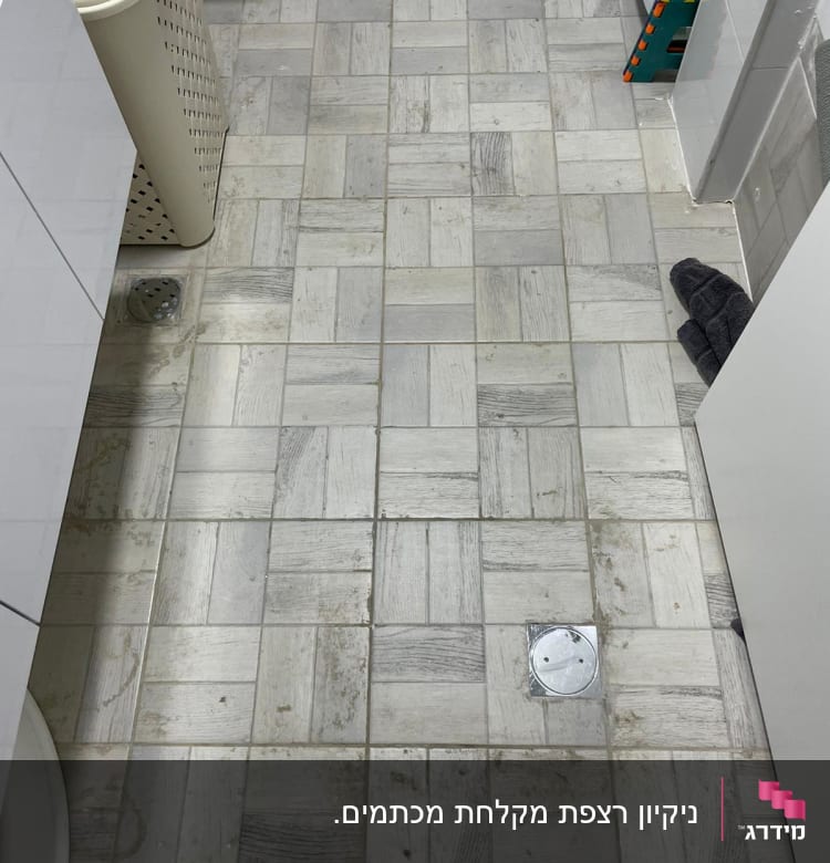 רצפה מלוכלכת עם כתמים, מגבת כהה בפינה